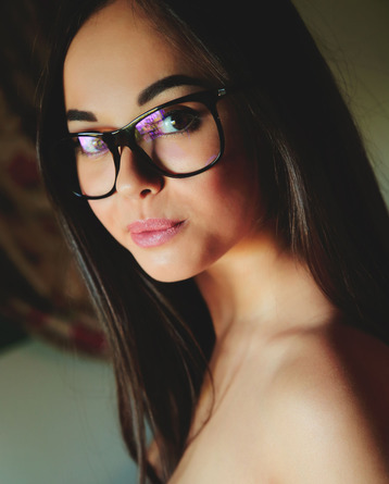 Petite, bespectacled beauty Li Moon reads a book in bed